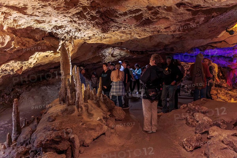 Tourists walking past limestone rock formations in a cave at Florida Caverns State Park in the Florida panhandle near Marianna