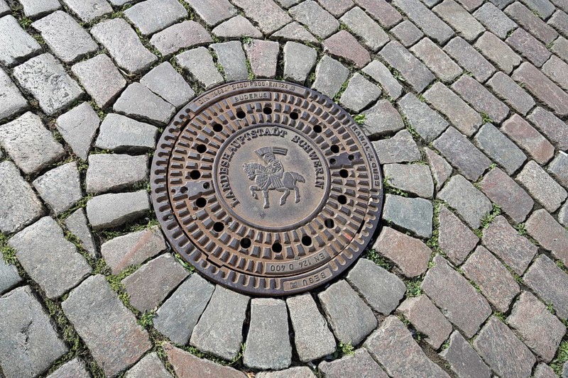 Round manhole cover with city coat of arms and inscription, state capital, paving stones, floor, Schwerin, Mecklenburg-Vorpommern, Germany