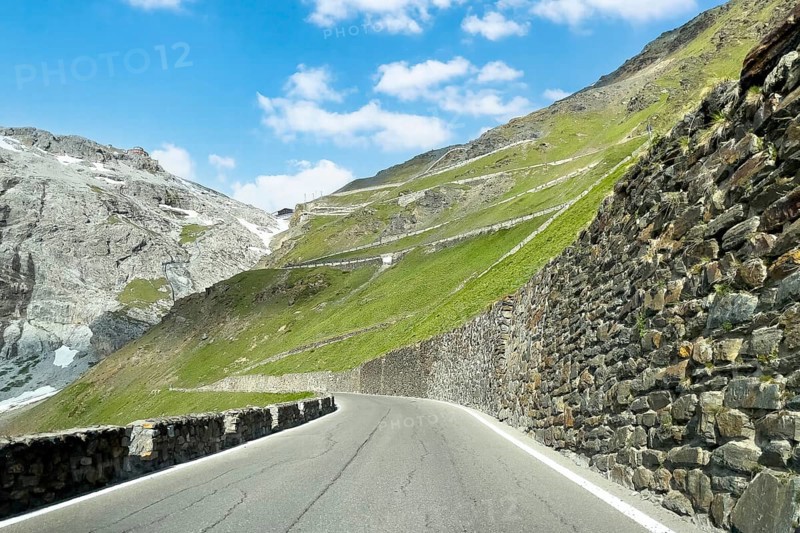 View of east ramp ascent to descent from Alpine pass Stelvio Stilfserjoch mountain road above tree line, right retaining wall wall of quarry stones, centre in the background many hairpin bends lead to pass summit of 2757 2758 metres high pass road mountain pass with tight bends hairpin bends Stilfser Joch Stelvio Stelvio, Stilfs, South Tyrol, Alto Adige, Italy