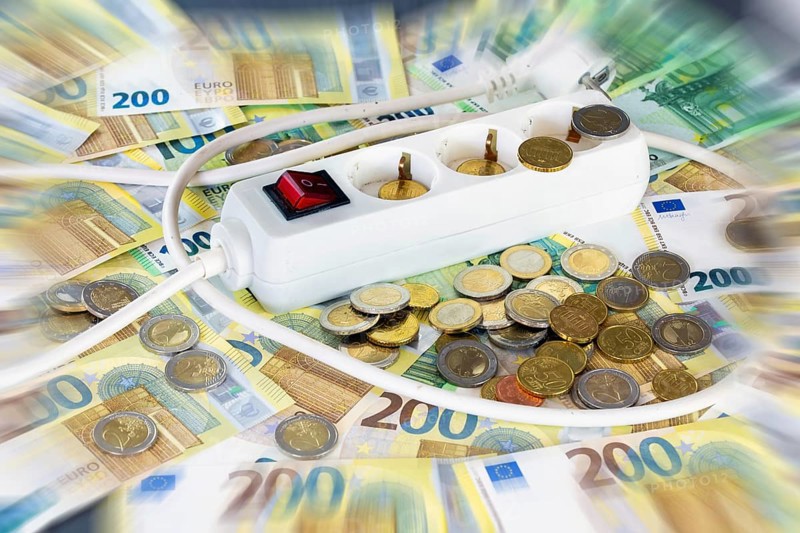 Symbolic image of electricity costs: multiple socket outlet with euro banknotes and euro coins