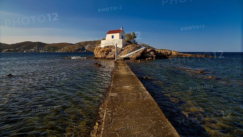 White chapel with red roof on a small island, connected to the mainland by a footbridge, chapel, church, Agios Isidoros, rocky islet, Bay of Gourna, Kokkali, Leros, Dodecanese, Greek Islands, Greece
