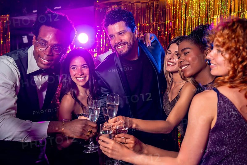 Happy multi ethnic friends celebrating new year's eve, toasting with champagne flutes at a glamorous party