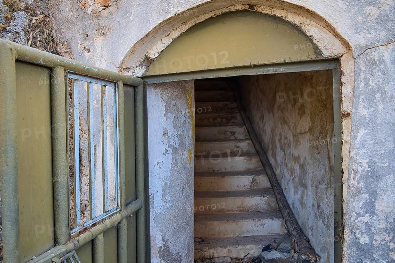 An open entrance with stairs leads into a dilapidated, secluded structure, Lost Place, Lago anti-aircraft battery, bunker, Apitiki Mountain, Leros, Dodecanese, Greek Islands, Greece