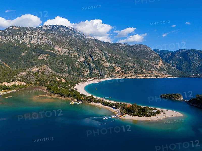 View of a beach with a peninsula surrounded by mountains and blue sea under a clear sky with clouds, aerial view, Fethiye, Mugla, Mugla, Aegean Sea, Turkey
