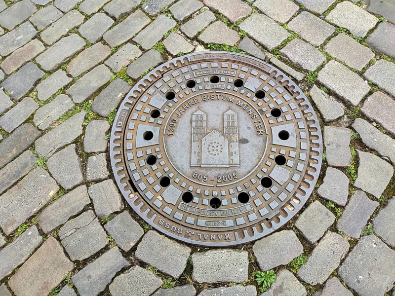 Manhole cover, manhole cover with the cathedral, cobblestones, Münster, Münsterland, North Rhine-Westphalia, Germany