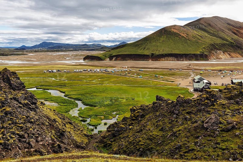 Hiking trail through volcanic landscape, lava rock, view of the campsite in Landmannalaugar, Icelandic highlands, Suðurland, Sudurland, Iceland