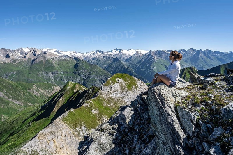 Mountaineer sitting on a rock in front of a mountain panorama with Großvenediger, mountain landscape with mountain peaks of the Venediger group, view from the summit of the Gösleswand, Lasörling group, Hohe Tauern National Park, East Tyrol, Tyrol, Austria