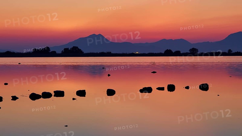 Dusk at the lake with dramatic sky and mountain silhouettes, salt lake, Tigaki, nature reserve, hydro biotope, Kos, Dodecanese, Greek Islands, Greece