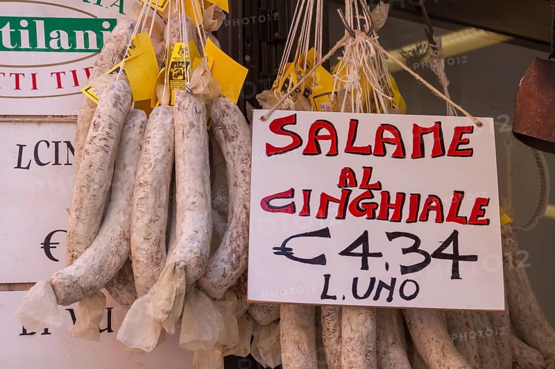Italian market stall with wild boar salami and price tag, Tuscany, Italy