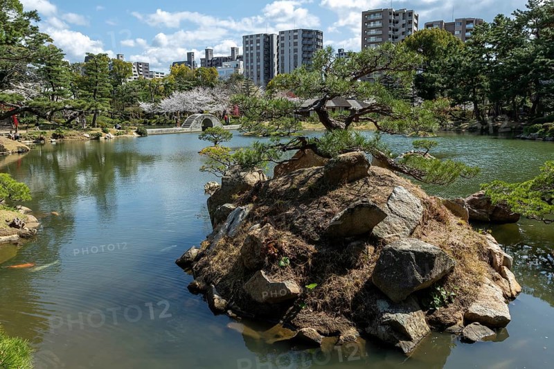 Shukkei-en with Sekisui-gan stone formation, green plants, trees and Koko-kyo stone bridge over Takuei-chi pond in spring, historical Japanese strolling garden, Japanese garden, green area, tourist attraction, sight, Naka-ku, Hiroshima, Japan
