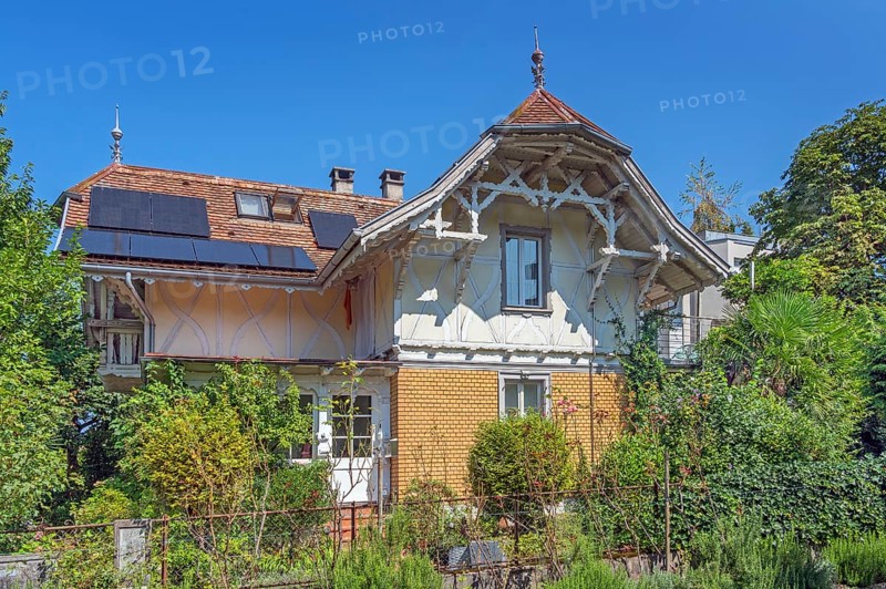 Interesting roof truss of a villa from around 1900, tiled roof with solar panels and a somewhat overgrown garden, Dornbirn, Vorarlberg, Austria