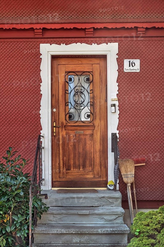 Red wooden shingle façade with wooden front door, Dornbirn, Vorarlberg, Austria