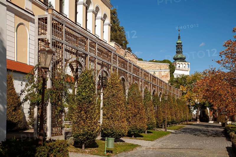 A well-tended garden with trees and antique lanterns in front of a series of arches, Mikulov Nikolsburg Czech Republic