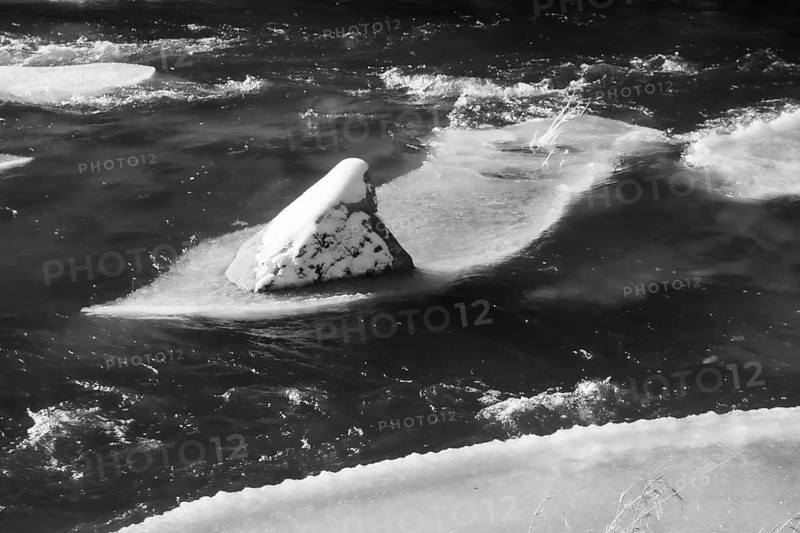 A rock in the river with a layer of snow and ice, Kamptal Waldviertel Austria
