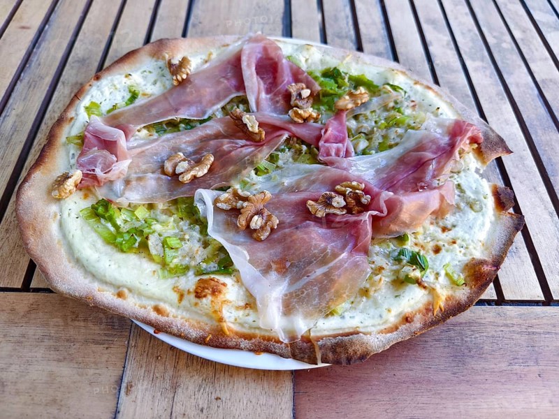 Close-up of a pizza tarte flambée with raw ham and walnuts, crispy base, served to a high standard, Lower Austria Austria