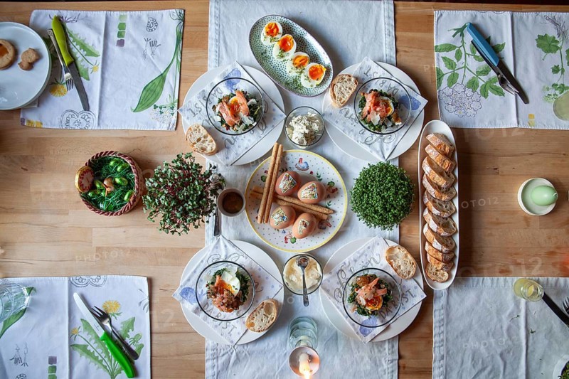 A stylishly laid table with a selection of fresh dishes, decorated with herbs and candlelight, Lower Austria Austria