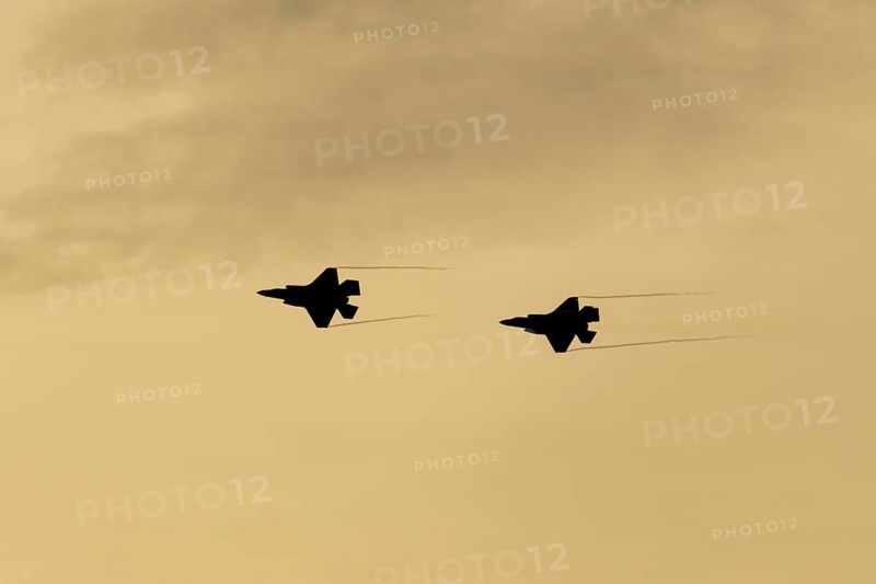 Lockheed Martin F-35 Lightning II fighter two military aircraft of the United States air force USAF silhouette in flight at sunset at RAF Lakenheath airbase, Suffolk, England, United Kingdom