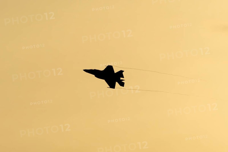 Lockheed Martin F-35 Lightning II fighter military aircraft of the United States air force USAF silhouette in flight at sunset at RAF Lakenheath airbase, Suffolk, England, United Kingdom