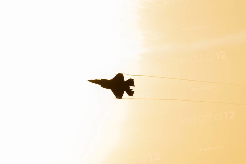 Lockheed Martin F-35 Lightning II fighter military aircraft of the United States air force USAF silhouette in flight at sunset at RAF Lakenheath airbase, Suffolk, England, United Kingdom