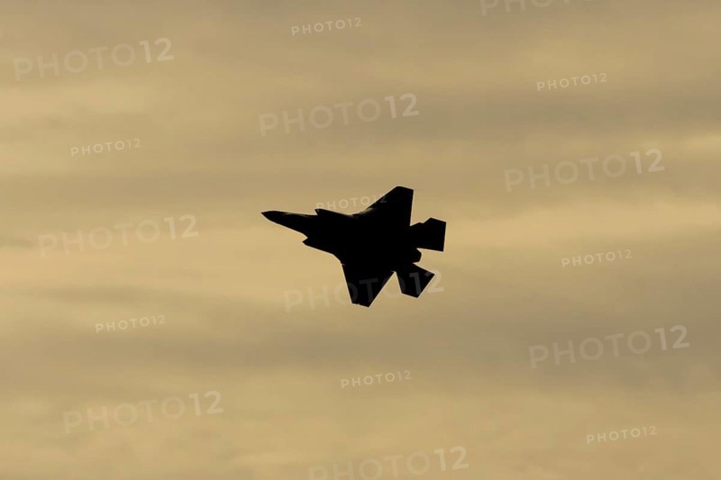Lockheed Martin F-35 Lightning II fighter military aircraft of the United States air force USAF silhouette in flight at sunset at RAF Lakenheath airbase, Suffolk, England, United Kingdom