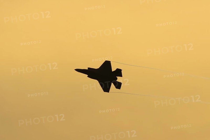 Lockheed Martin F-35 Lightning II fighter military aircraft of the United States air force USAF silhouette in flight at sunset at RAF Lakenheath airbase, Suffolk, England, United Kingdom