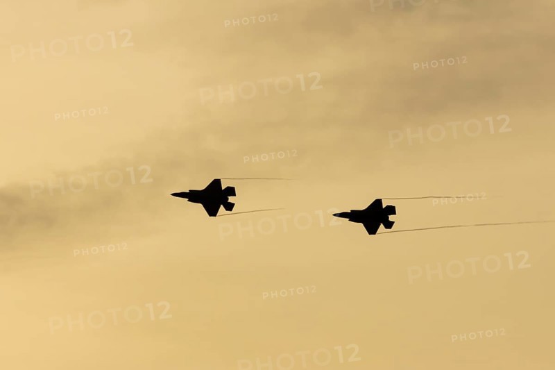 Lockheed Martin F-35 Lightning II fighter two military aircraft of the United States air force USAF silhouette in flight at sunset at RAF Lakenheath airbase, Suffolk, England, United Kingdom