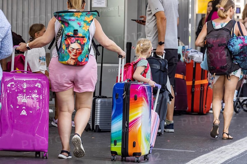 Stuttgart main station. Group of travellers on the platform with colourful suitcases. Stuttgart, Baden-Württemberg, Germany