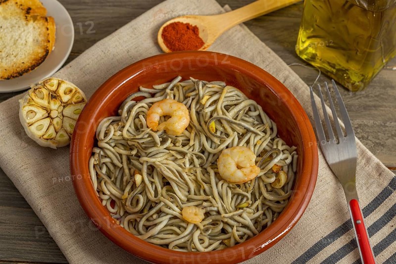 Gulas with garlic prawns in earthenware casserole dish