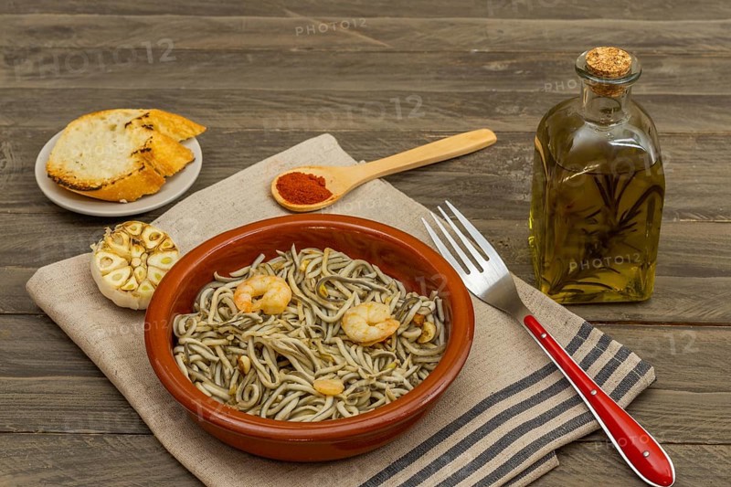 Gulas with garlic prawns in earthenware casserole dish