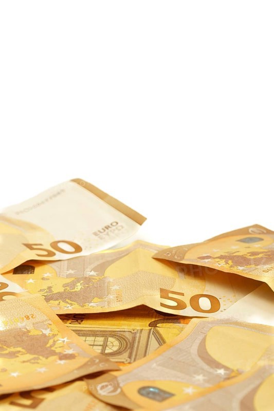 Scattered fifty euro banknotes forming a corner frame on a white background, ideal for finance and investment concepts