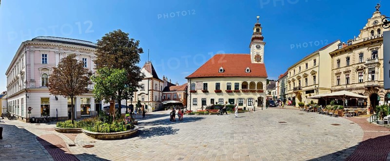 Panoramic view of a town square with historic clock tower and surrounding buildings under a clear sky Mödling Lower Austria Austria