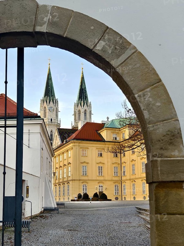 View through a stone gate onto a baroque building with two Gothic church towers, Klosterneuburg Lower Austria Austria
