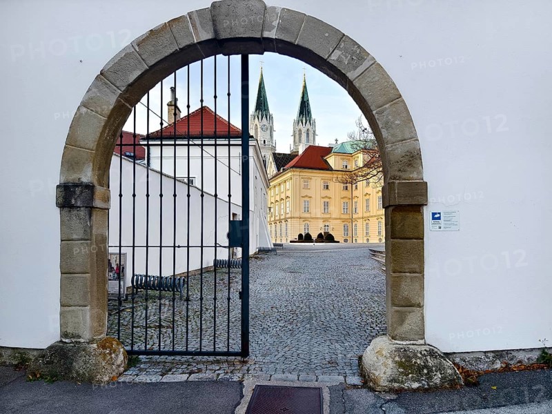 View through a Tor tor to a cobbled courtyard and church towers of a historic building, Klosterneuburg Lower Austria Austria