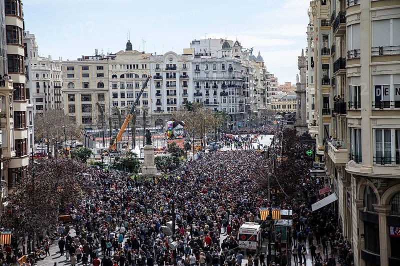 Large crowd in the city centre with tall buildings in the background MascletÃ¡ de Fallas