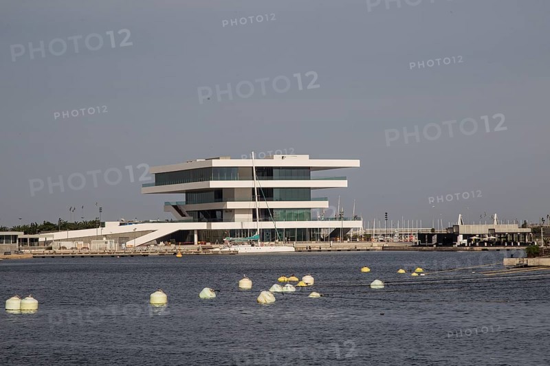 Modern building with clean lines on the water, surrounded by buoys