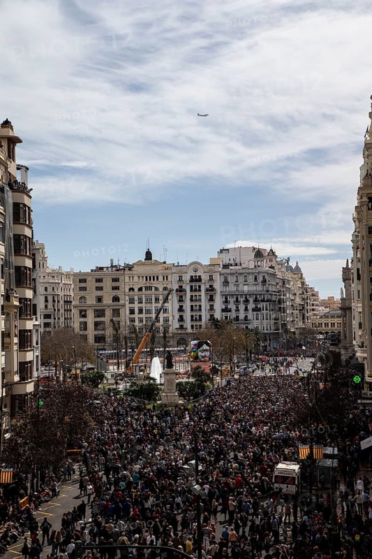 Large crowd in a city in front of tall buildings and a slightly cloudy sky MascletÃ¡ de Fallas