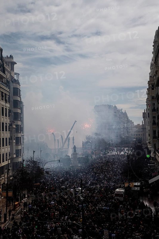 Large gathering of people in a smoky cityscape MascletÃ¡ de Fallas