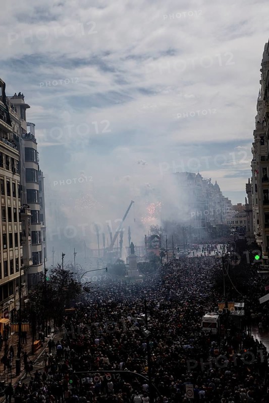 Large crowds in the city with billows of smoke and urban background MascletÃ¡ de Fallas