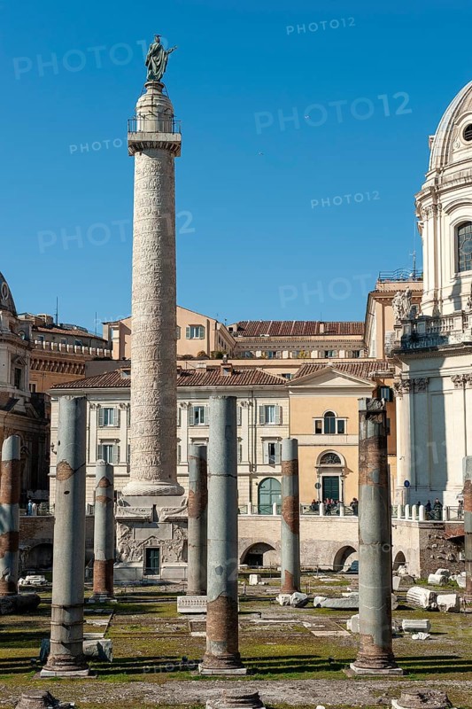 View of part of historic Trajan's Forum with ancient column fragments from Basilica Ulpia in front, behind it 40 metre high column of honour Victory Column from the year 113 made of Carrara marble from Lunensian marble for Roman Emperor Trajan from antiquity, at the top statue of Apostle Peter Saint Peter, Saint Peter, erected in 1587 at the behest of Pope Sixtus V, below small platform with railing, Rome, Lazio, Italy