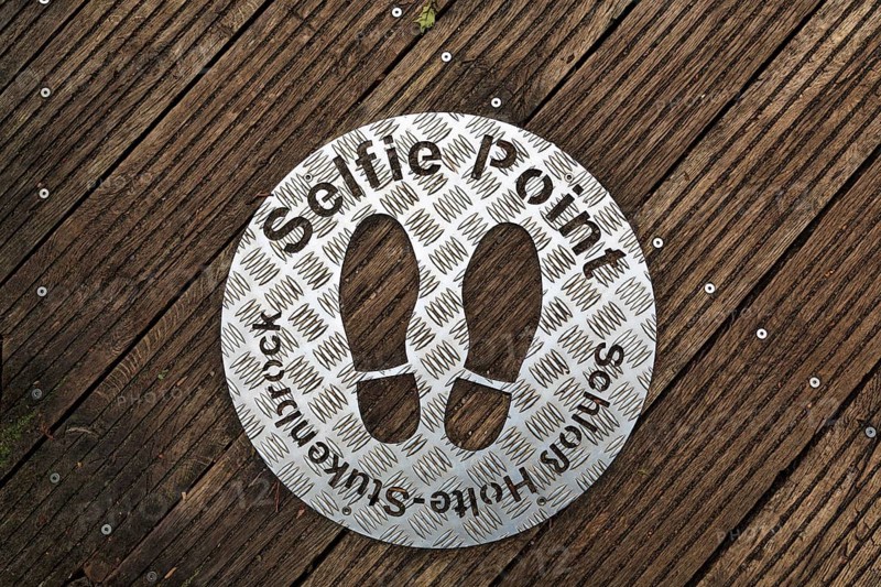 Selfie point, metal plate, shoe prints on a plank path at the source of the River Ems near Schloss Holte-Stukenbrock, Senne nature reserve, North Rhine-Westphalia, Germany