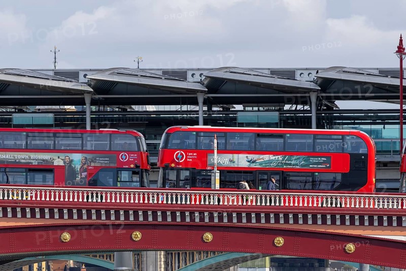 Two red double decker buses driving over a bridge, City of London, England, United Kingdom
