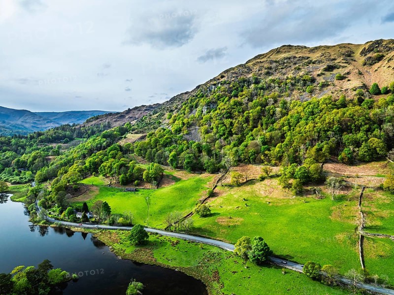 Farms and Mountains over road A591 from a drone, Grasmere Lake, Grasmere, Ambleside, Lake District, Westmorland, Cumbria, UK
