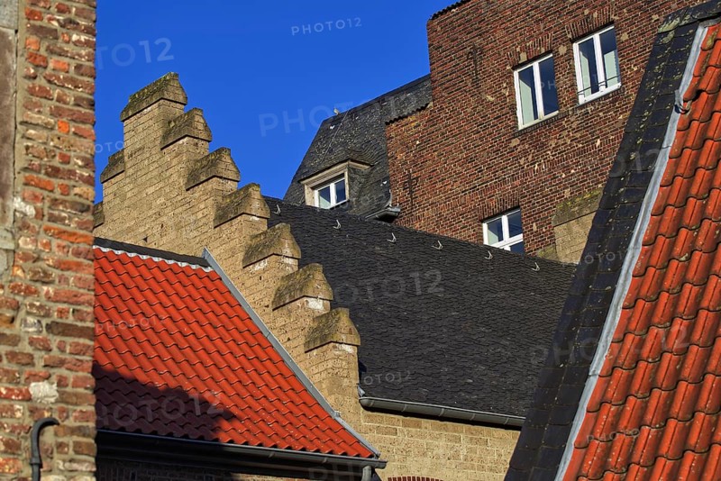 Different roof styles and brick wall under a clear blue sky, DÃ¼sseldorf
