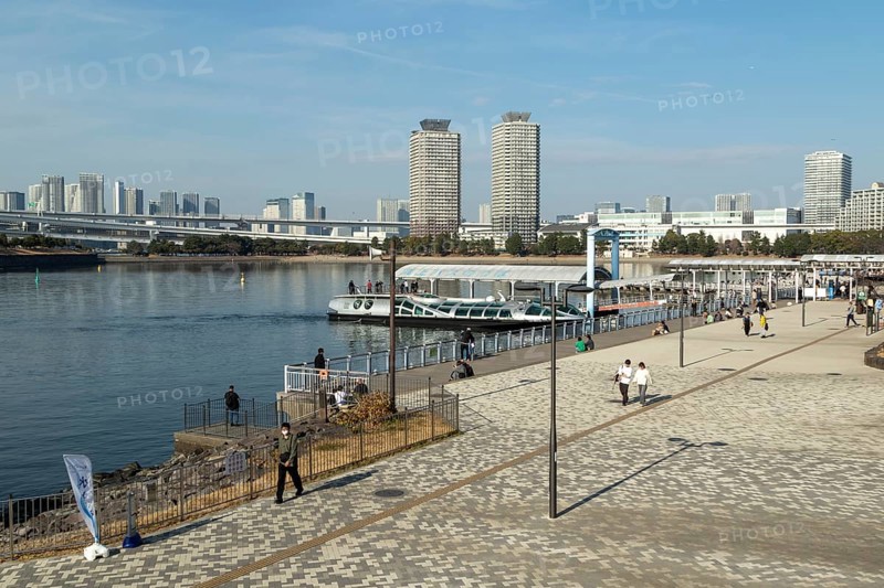 Strollers on the promenade and futuristic Tokyo Cruise Water Bus Queen Emeraldas, excursion boat for harbour cruises in Tokyo Bay, Odaiba, Minato City, Tokyo, Japan
