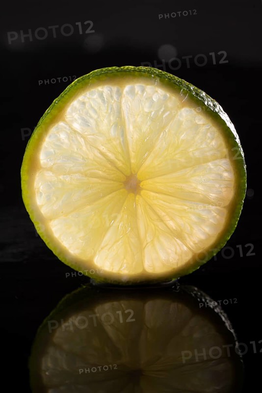 Slice of lime on stone slab with reflection