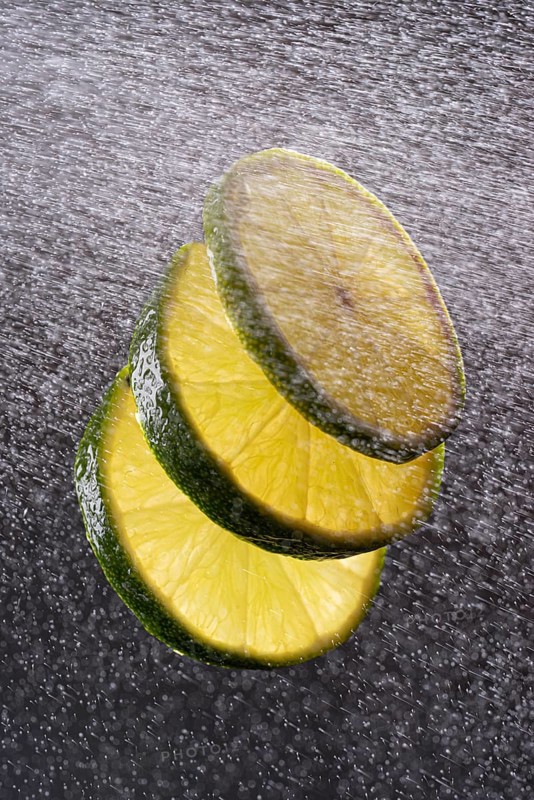 Three lime slices with drops of water