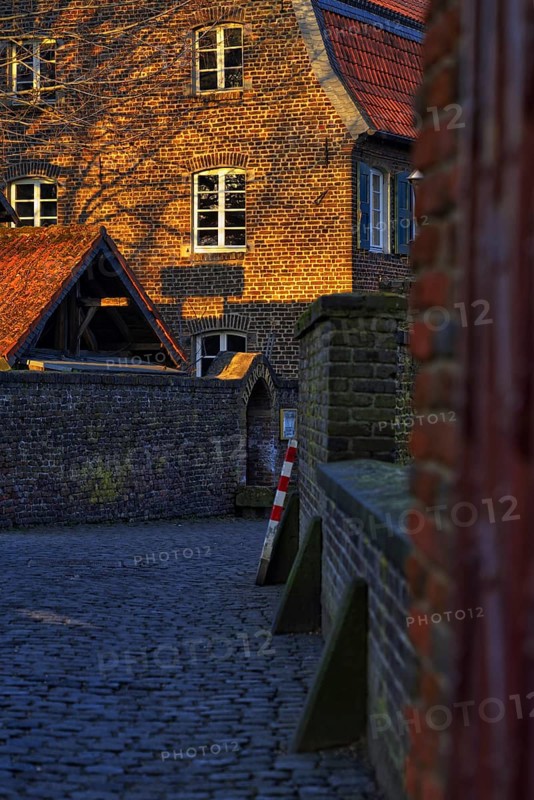 Old brick building in warm evening light with striking gable, Krefeld