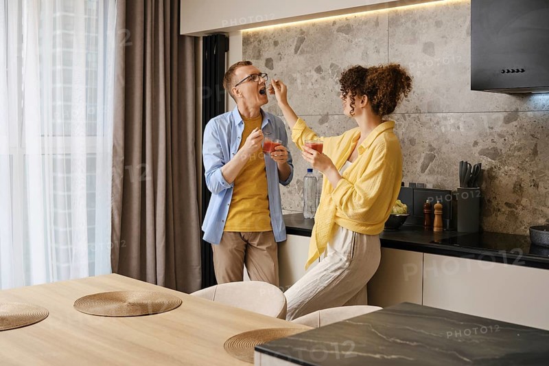 The woman playfully feeds the man a bite of food, showcasing their connection and joy