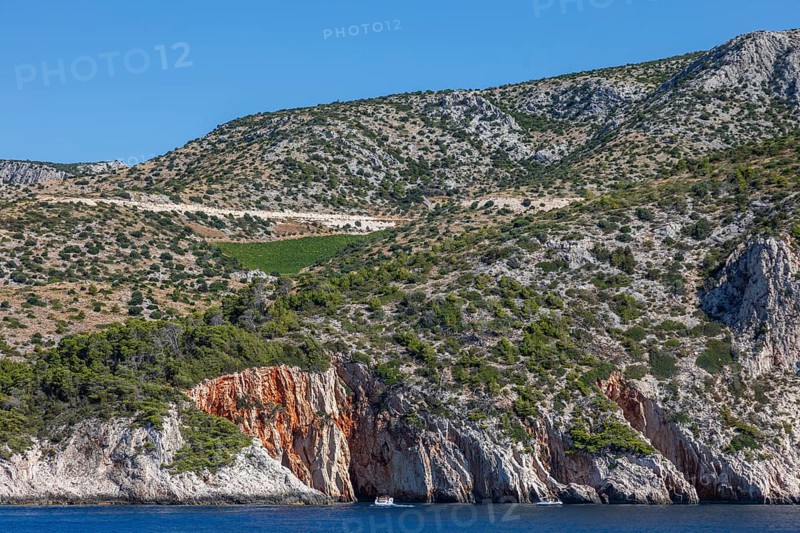 View from the sea to the red rocks, island of Hvar, Dalmatia, Croatia