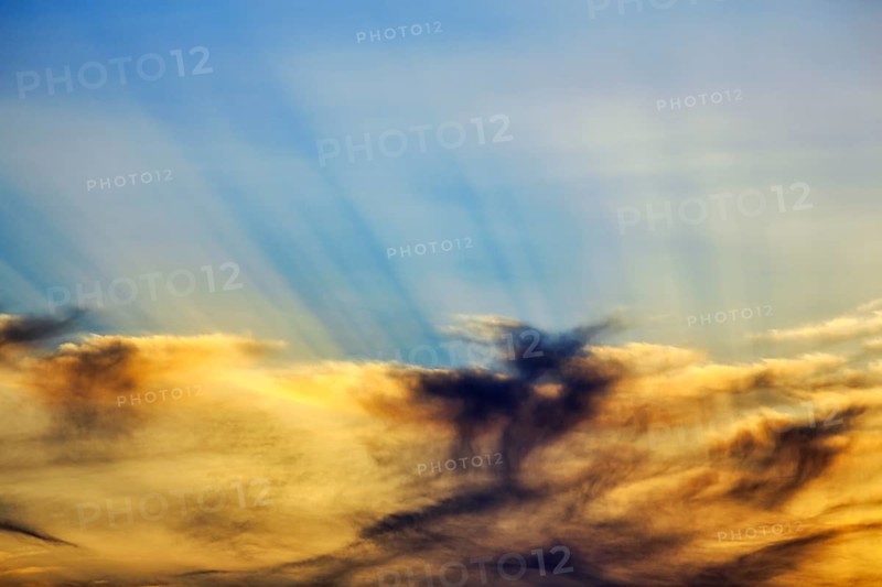 Sunset behind cloud cover, sunbeams, Oia, Thira, Santorini, Cyclades, Greece